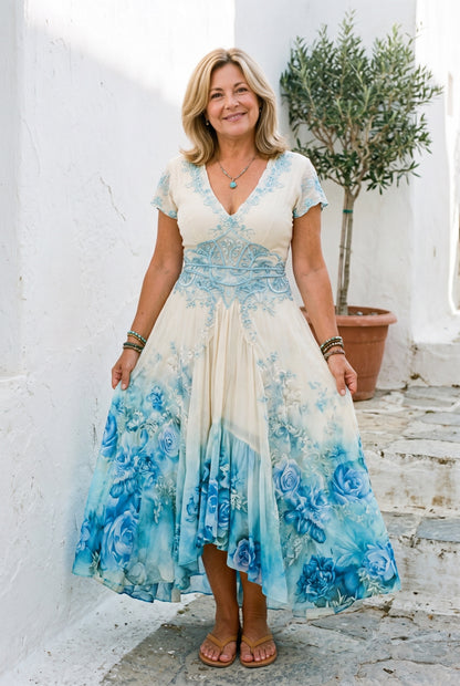 The Joanne Patio Dress in beige with blue florals, boho handkerchief-hem maxi