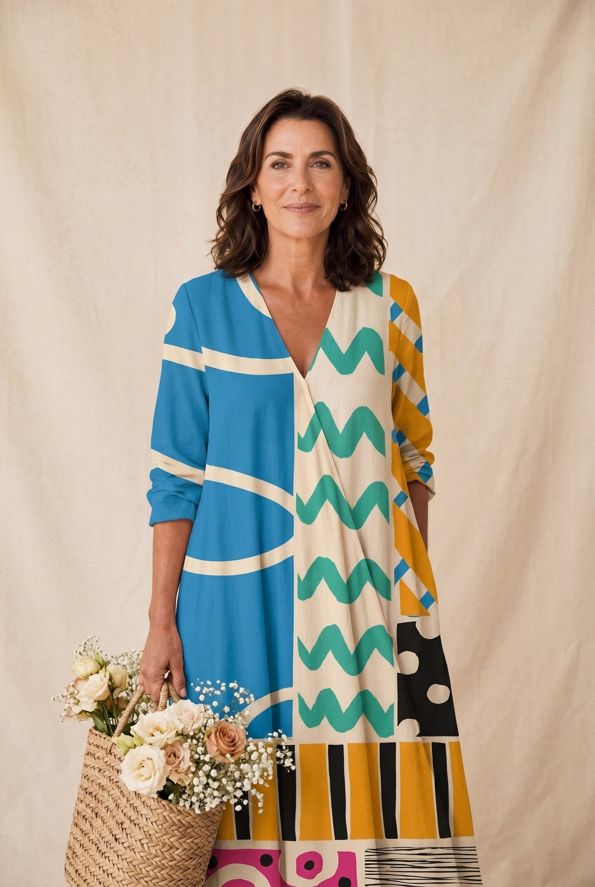The Linda Five O'Clock Dress in bold cobalt, mustard, and cream chevron print, full-length editorial portrait with floral basket against a cream studio backdrop